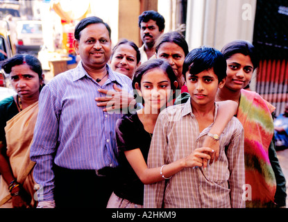 Estesa famiglia indù includente un servo dopo la puja (rituale di culto) che pongono al cortile del tempio Mahalaximi. Mumbai, India Foto Stock