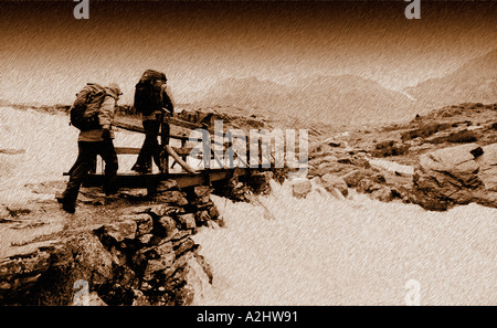 2 persone che indossano Attrezzatura per alpinismo Passeggiate attraverso un ponte in montagna. Foto Stock