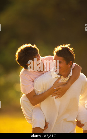 Gru per l uomo la sua testa indietro a guardare la donna sorridente ha felicemente porta sovrapponibile all'aperto Foto Stock