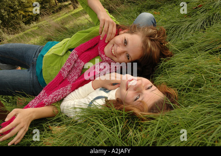 Due sorelle adolescenti allegramente scorazzare in erba Foto Stock