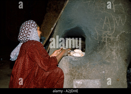 Africa - Egitto - Luxor - Accampamento Beduino - Tipico Tented Camp, donna beduina la cottura del pane nel forno di fango Foto Stock