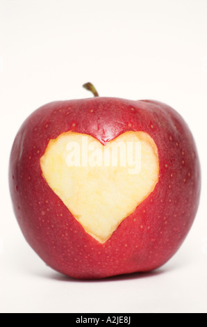 Forma di cuore simbolo sulla mela rossa contro uno sfondo bianco Foto Stock