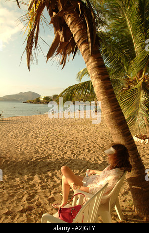 Una donna si siede su una sedia sul Oualie Beach Foto Stock