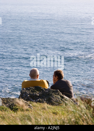 Di mezza età giovane godendosi un po' di sole invernale sulla costa al punto di partenza, Devon. Regno Unito Foto Stock