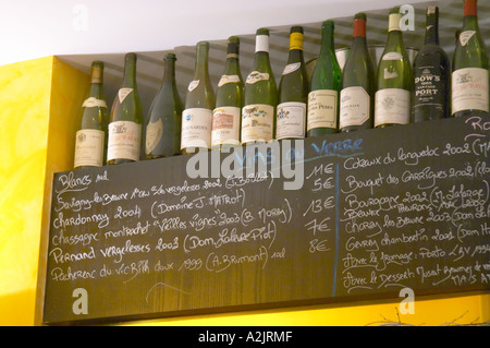 Una lavagna lavagna nera chalk board con la lista dei vini con vini serviti al bicchiere (Vins Au Verre), Savigny les Beaune, Chardonnay, Chassagne Montrachet, Pernand Vergelesses, Pacherenc de Vic Bilh" Coteaux du Languedoc, Bourgogne, Chorey les Beaune Gevrey Chambertin, con una selezione di esclusivi bottiglie sullo scaffale che è stato bevuto in enoteca winebar al ristorante Le Gourmandin in Beaune Cote d'Or Borgogna Borgogna Francia Europa Foto Stock