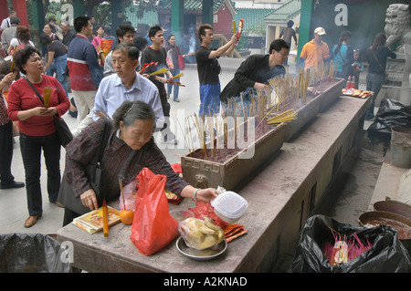 I credenti pregano e sacrificare a Wong Tai Sin tempel Foto Stock