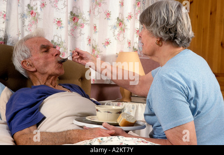 Donna matura cucchiaio Zuppa di alimentazione per malati anziani uomo Foto Stock