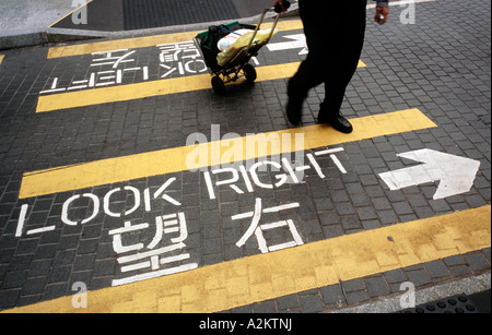 Settembre 11, 2006 - Indicazioni stradali raccontando i pedoni che modo di guardare fuori per il traffico quando si attraversa la strada in Hong Kong. Foto Stock