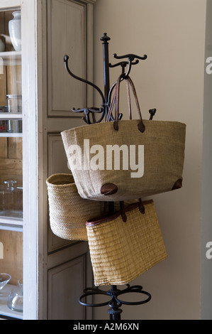 Hessian e basket weave shopping bags appendere su un originale hat stand Foto Stock