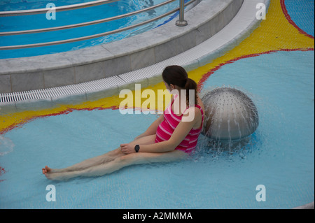 Donna incinta seduta in acqua Foto Stock