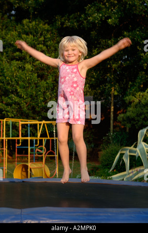 4 anno vecchia ragazza saltando su un trampolino. Foto Stock