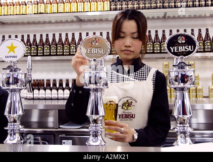 Il barista versa la birra fresca presso il bar i visitatori in originale Sapporo birra birreria in Sapporo Hokkaido , Hokkaido, Giappone Foto Stock