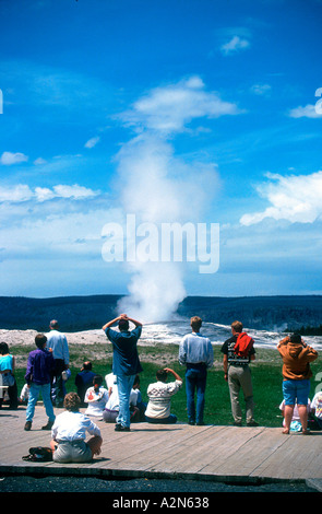 Parco i visitatori guarda geyser Old Faithful Parco Nazionale di Yellowstone Wyoming USA Foto Stock