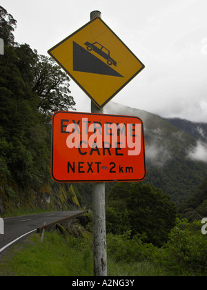 Strada segno di pericolo sulla strada che conduce a Haast Pass nelle alpi del sud sulla South Island, in Nuova Zelanda. Foto Stock