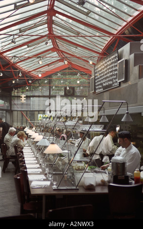 Regno Unito Inghilterra Londra interno del ristorante di pesce a Borough Market. Diners e gli chef in aperto cucina pianificata Foto Stock