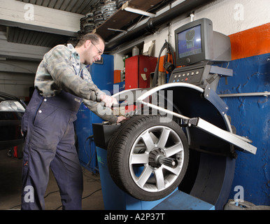 Il meccanico Frank Michels saldi i pneumatici del veicolo a motore officina Foto Stock