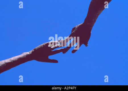 La famiglia dell'uomo sculture (artista: Mario Armengol), Calgary, Alberta, Canada - aiutando le mani arrivando a dare una mano Foto Stock