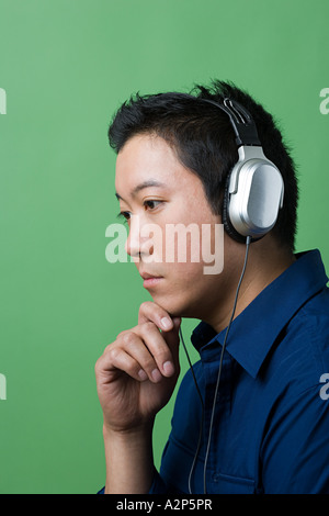 Uomo che indossa le cuffie e pensare Foto Stock