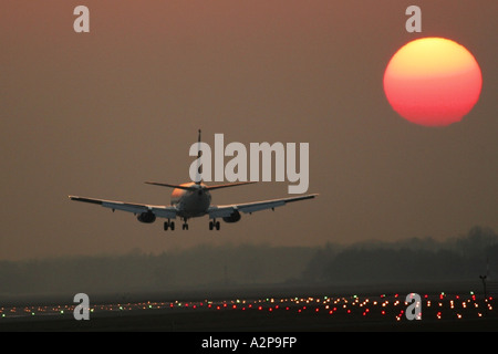 Aereo passeggeri di atterraggio su aeroporto di Monaco al tramonto, in Germania, in Baviera, Monaco di Baviera Foto Stock
