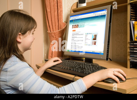 11 enne white British School girl e-mail sul computer di casa Foto Stock