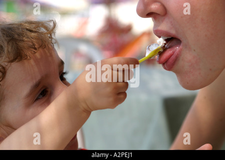 Bambina dando gelato a sua madre Foto Stock
