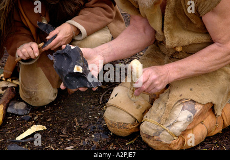 Professional Stoneage reenactors knapping selce presso il Museum of Welsh Life St Fagans Cardiff Wales UK Foto Stock