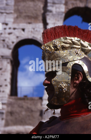 Uomo vestito come un soldato Romano sorge al di fuori del Colosseo a Roma Foto Stock