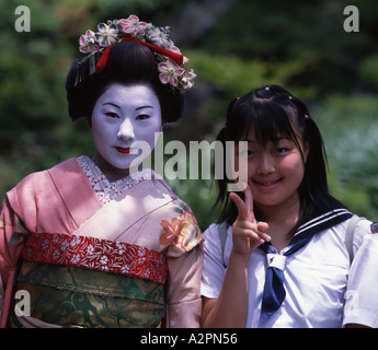 Junior High School girl pone con la donna in maiko partecipante Geisha costume in giardino giapponese di Kyoto Gion indossare il kimono Foto Stock