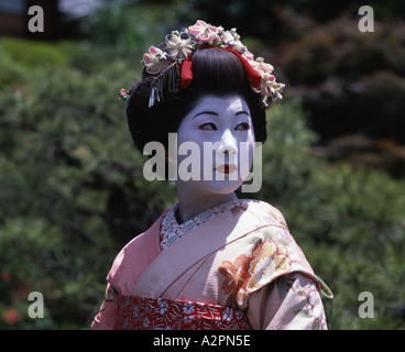 La ragazza di maiko partecipante Geisha costume in giardino giapponese di Kyoto Gion indossare il kimono obi parrucca parasol trucco rossetto Foto Stock