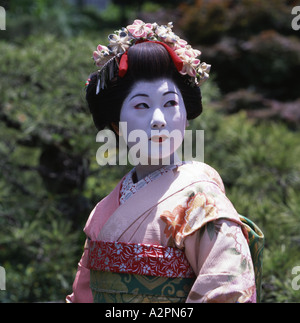La ragazza di maiko partecipante Geisha costume in giardino giapponese di Kyoto Gion indossare il kimono obi parrucca parasol trucco rossetto Foto Stock