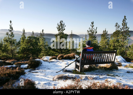 Un maschio singolo walker in appoggio su un bancale in cima Craigendarroch collina vicino a Ballater trovanella Cairngorm National Park Foto Stock