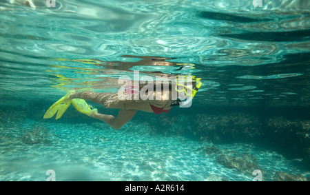 La donna lo snorkeling su shallow fondo sabbioso in bikini rosso Foto Stock