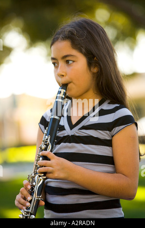 Una bambina di dieci anni svolge il suo clarinetto in un parco di Los Angeles California Modello rilasciato Foto Stock