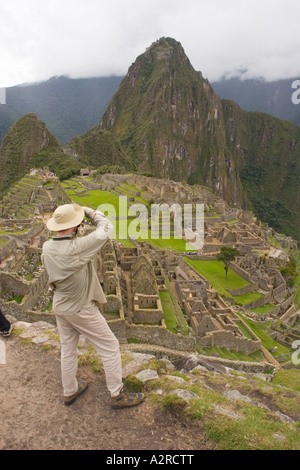 Fotografo turistico e vista sulla cittadella di Machu Picchu Sito incluse Huaynu Picchu in Perù di sfondo Foto Stock