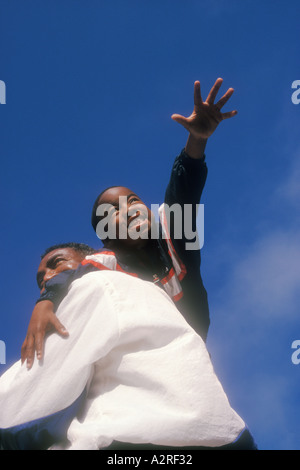 7 anno vecchio African American boy sulla spalla padri Foto Stock