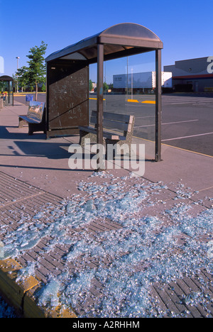 Atti di vandalismo presso la fermata degli autobus, vandalizzato Bus Shelter - rotto cocci di vetro sul marciapiede Foto Stock