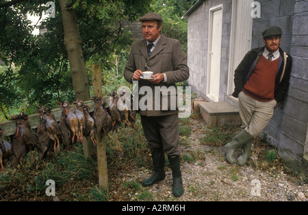 Game Keepers all'esterno del rifugio di caccia Guns, ospiti della tenuta che mangiano un pasto caldo Gurston Down Partridge Shoot Wiltshire Inghilterra, HOMER SYKES anni '2000 Foto Stock