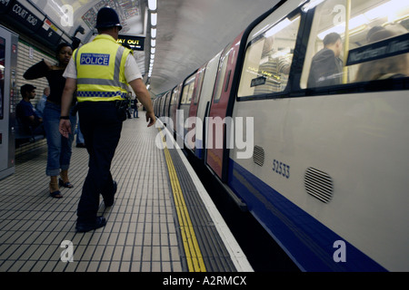 La AMID rafforzate le misure di sicurezza dopo il 7 luglio 2005 attentati di Londra un funzionario di polizia pattuglia la metropolitana di Londra Foto Stock