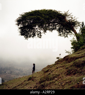 Una giovane donna si erge su una collina che si affaccia sul sito dell'ex hayk sito di rifugiati, Etiopia Foto Stock