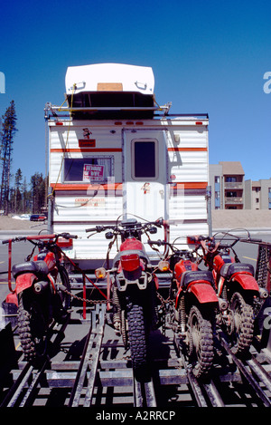 RV Camper pickup camion che trasportano canotto sul tetto e tirando il rimorchio caricato con il motocross Dirt Bike Foto Stock