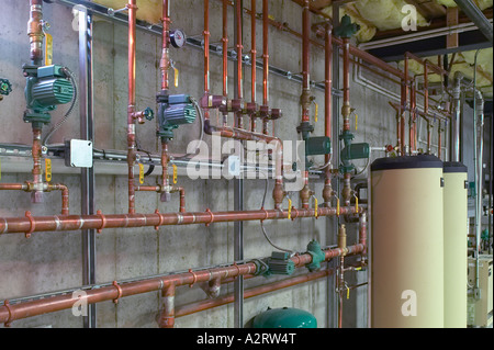 Rame metallico in tubazioni di acqua calda con riscaldatori di acqua nel seminterrato Foto Stock