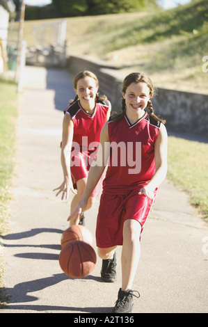Le ragazze adolescenti dribbling basketballs Foto Stock