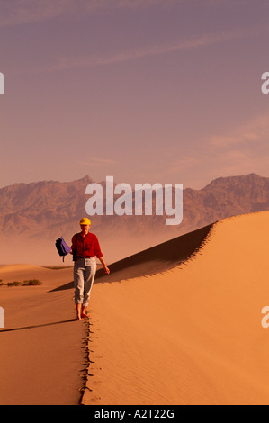Parco Nazionale della Valle della Morte, California, Stati Uniti d'America - duna di sabbia di Sunrise, Escursionista escursionismo su Mesquite dune di sabbia vicino a tubo da stufa di pozzetti Foto Stock
