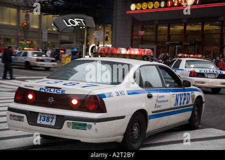 Vetture NYPD lasciando Times Square Manhattan a velocità. New York STATI UNITI D'AMERICA Foto Stock