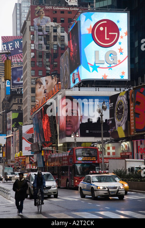 Pedoni, con tabelloni elettronici sulla costruzione di Bertelsmann. Times Square a New York City USA Foto Stock