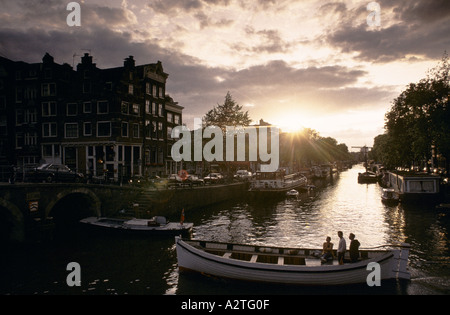 Amsterdam persone godendo il sole serale a bordo di una barca sul canal amsterdam Foto Stock