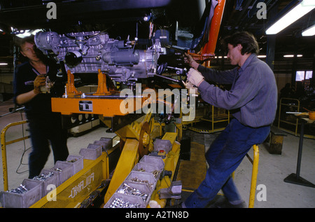 Lavoratori auto di montaggio delle parti del motore sulla linea di produzione in fabbrica skoda 1992 Foto Stock