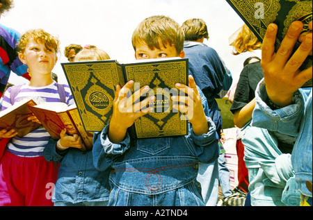 Bosnia centrale giugno 1995 rifugiati arrivano dalla Macedonia per tornare a Sarajevo i bambini la lettura del Corano Foto Stock