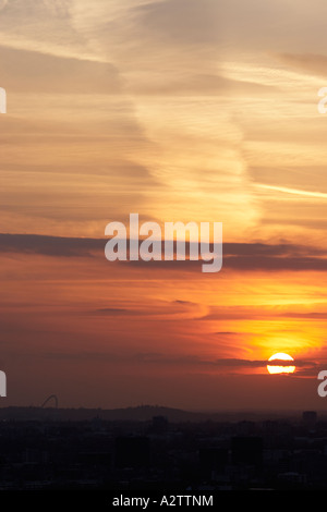 Tramonto con il sole che tramonta nel cielo arancione oltre lo stadio di Wembley che dalla città di Londra EC2 England Regno Unito Foto Stock