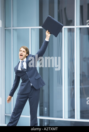 Imprenditore valigetta oscillante e urlando Foto Stock